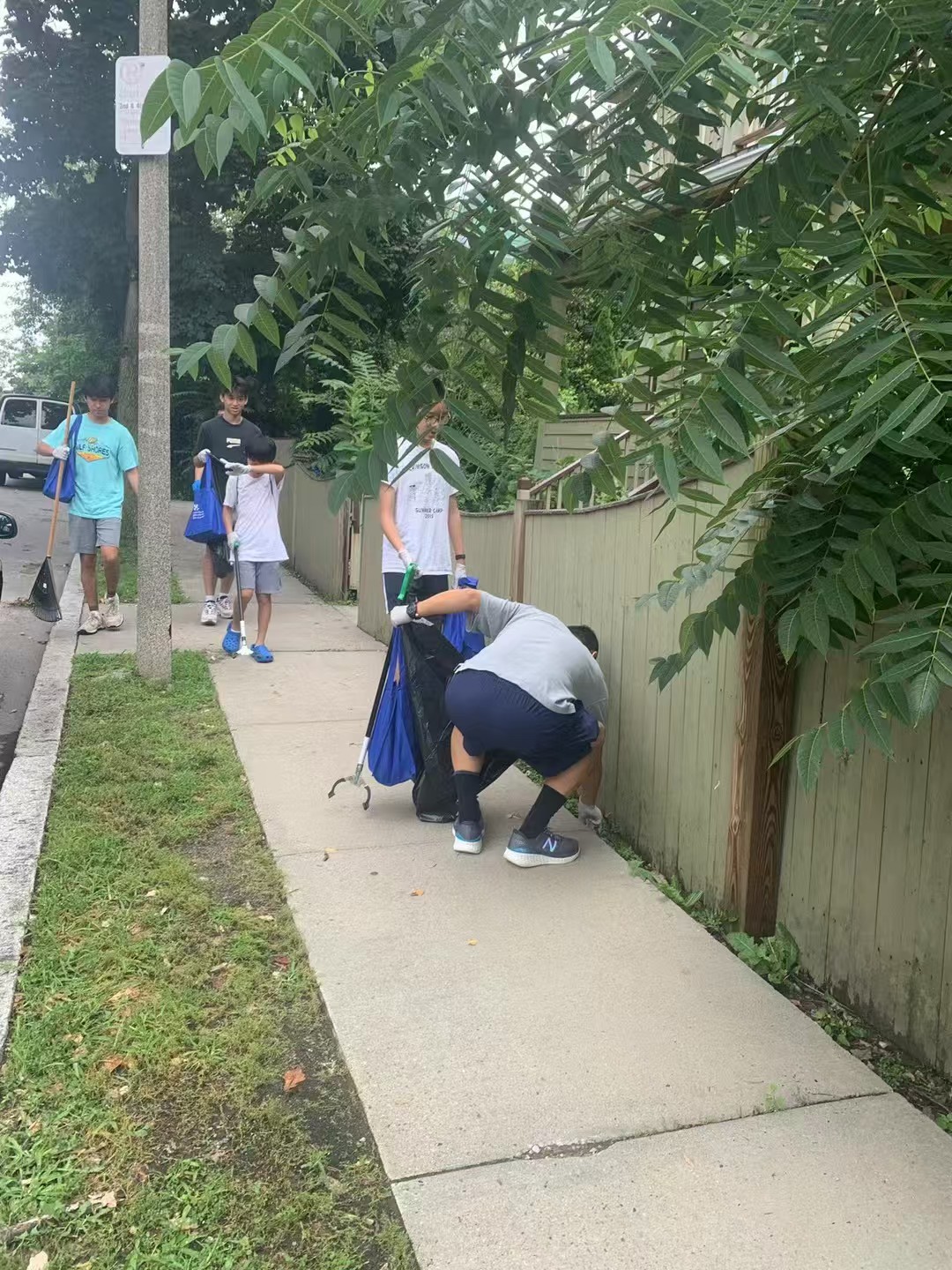 Volunteers collecting litter along a residential sidewalk